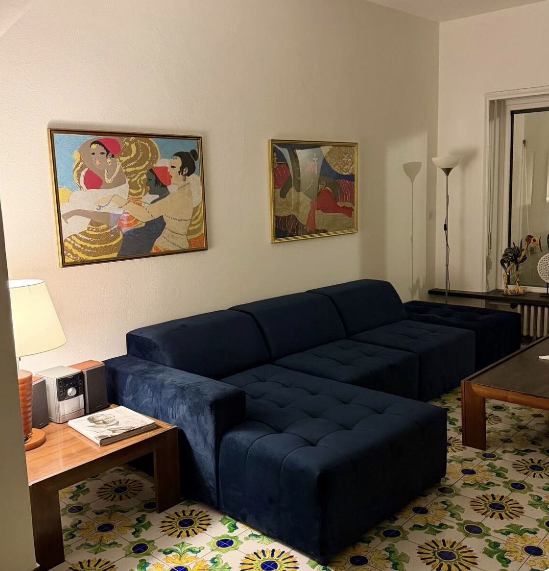 Living room with deep blue sofa and framed artwork